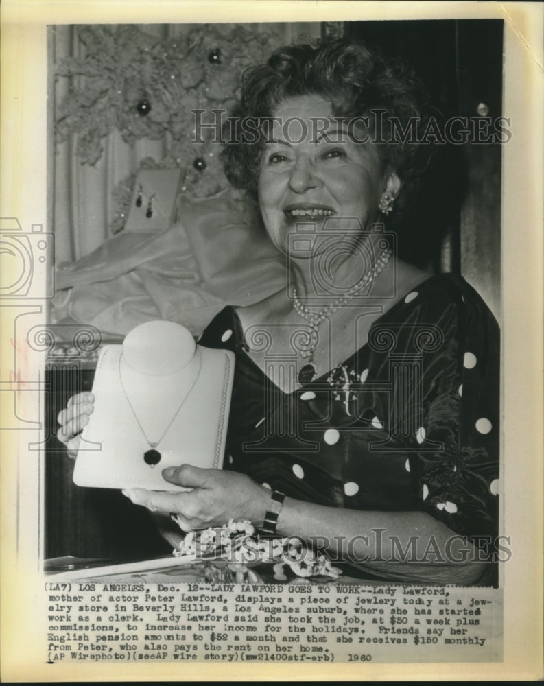 1960 Press Photo Lady Lawford shows a piece of jewelry in a store she works at-Historic Images