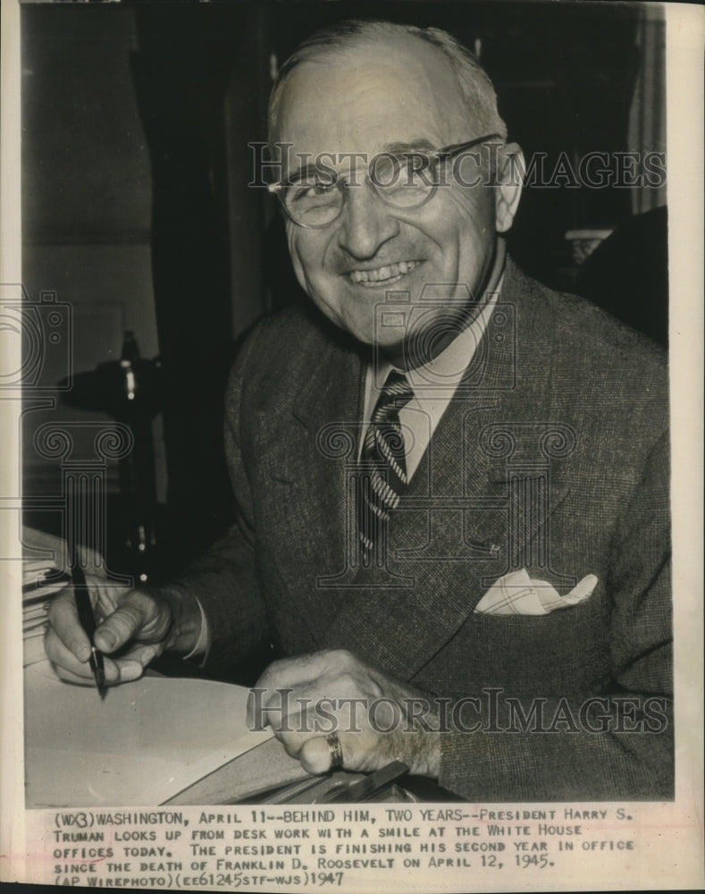 1947 Press Photo President Harry S Truman smiles while working from his desk-Historic Images