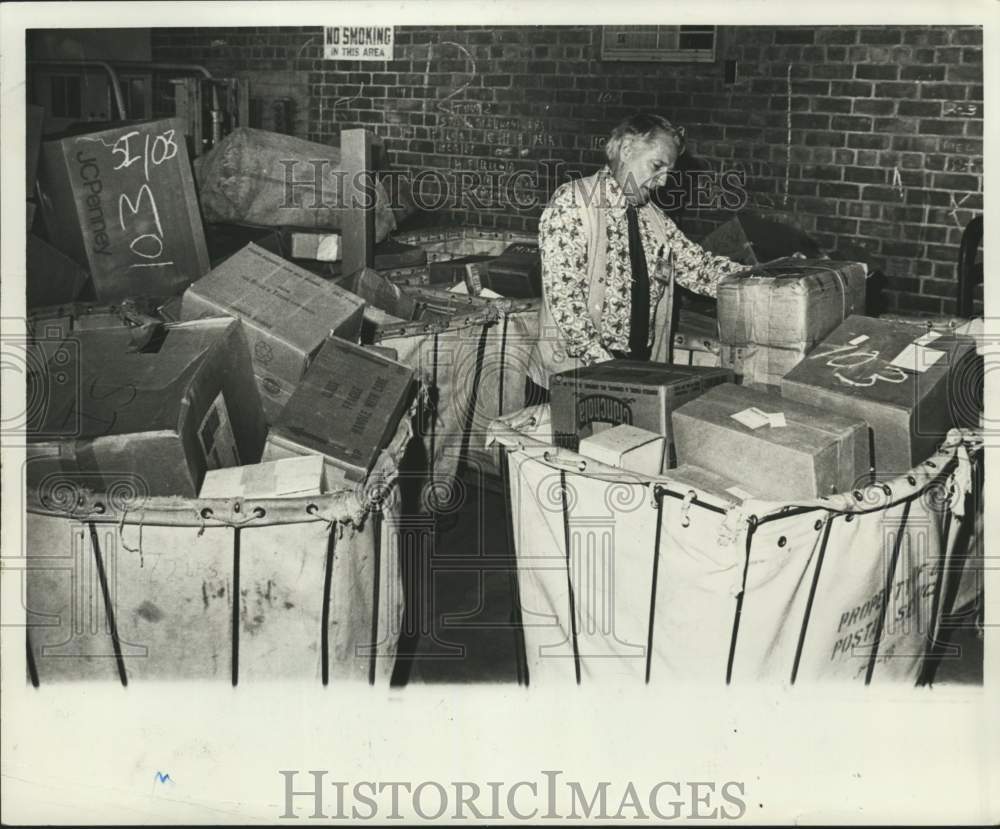 1976 Press Photo Postal worker Joseph Sullivan sorting packages by zip code - Historic Images