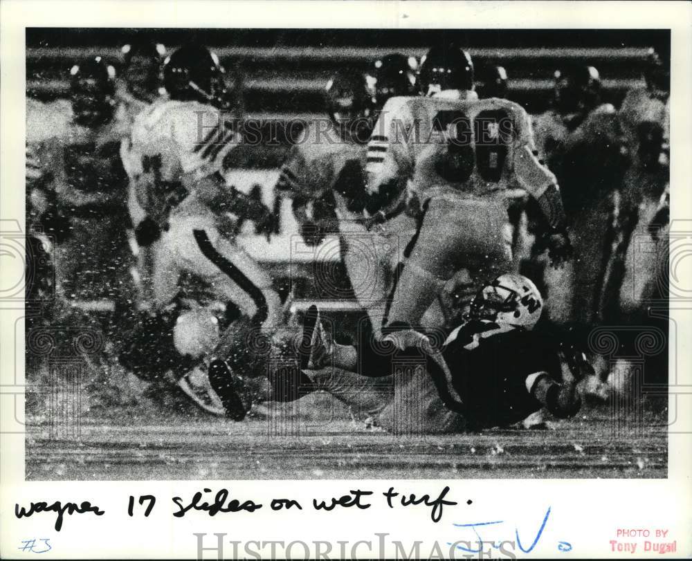 1984 Press Photo Wagner College football's #17 slides on wet turf during game - Historic Images