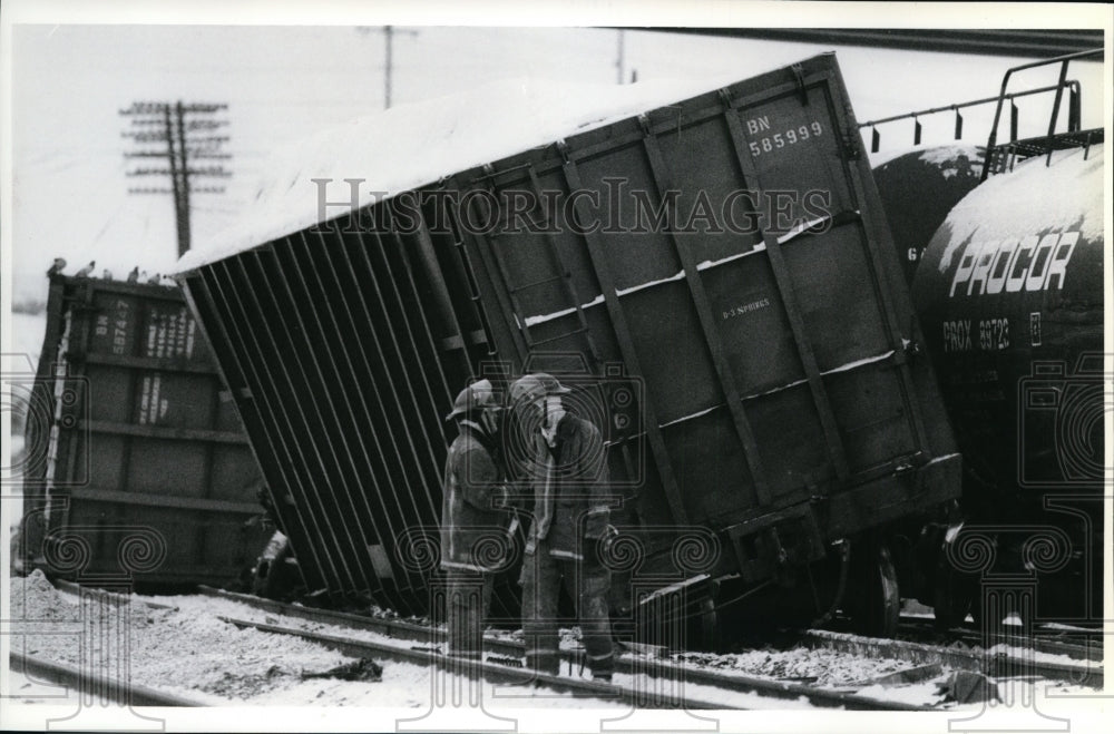 1991 Press Photo Spokane firefighters on derailed car near Hamilton Street - Historic Images