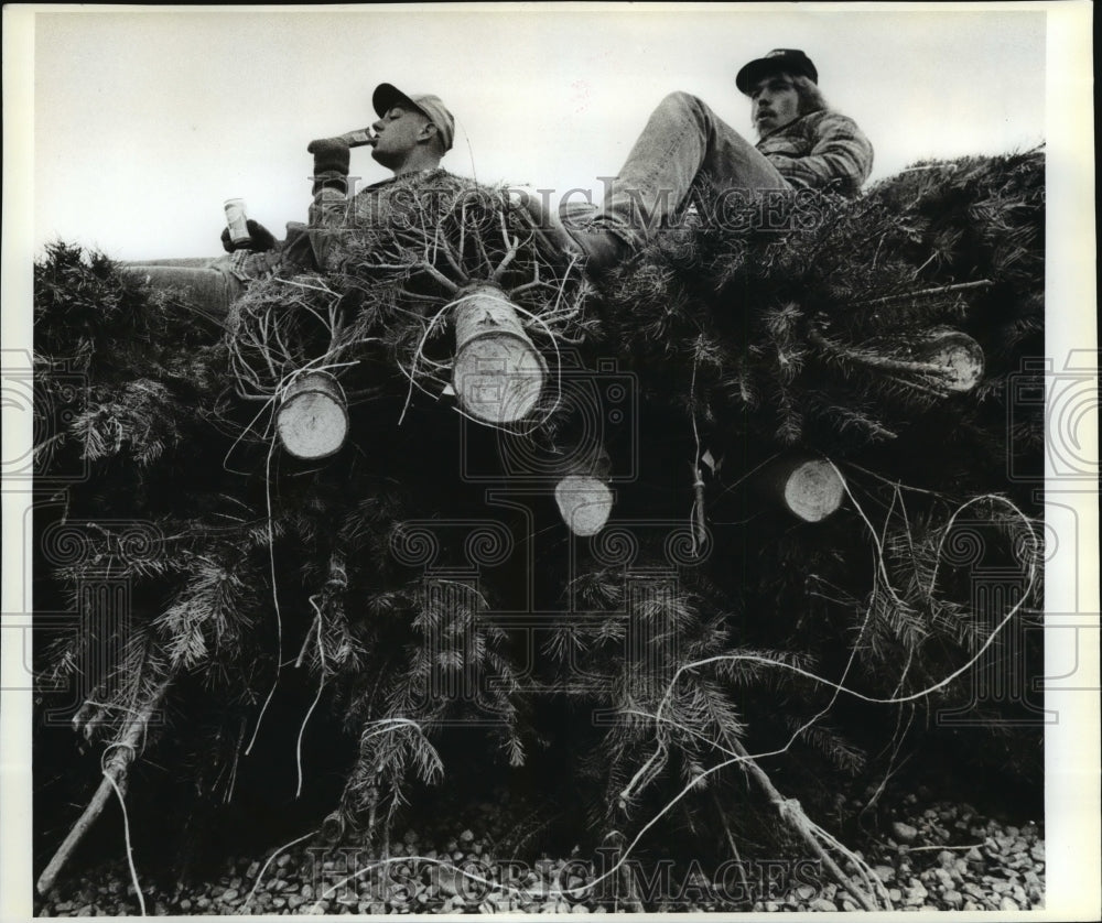 1987 Press Photo Erik Turrell &amp; Joe Ehrlich unload cut trees on East Sprague-Historic Images