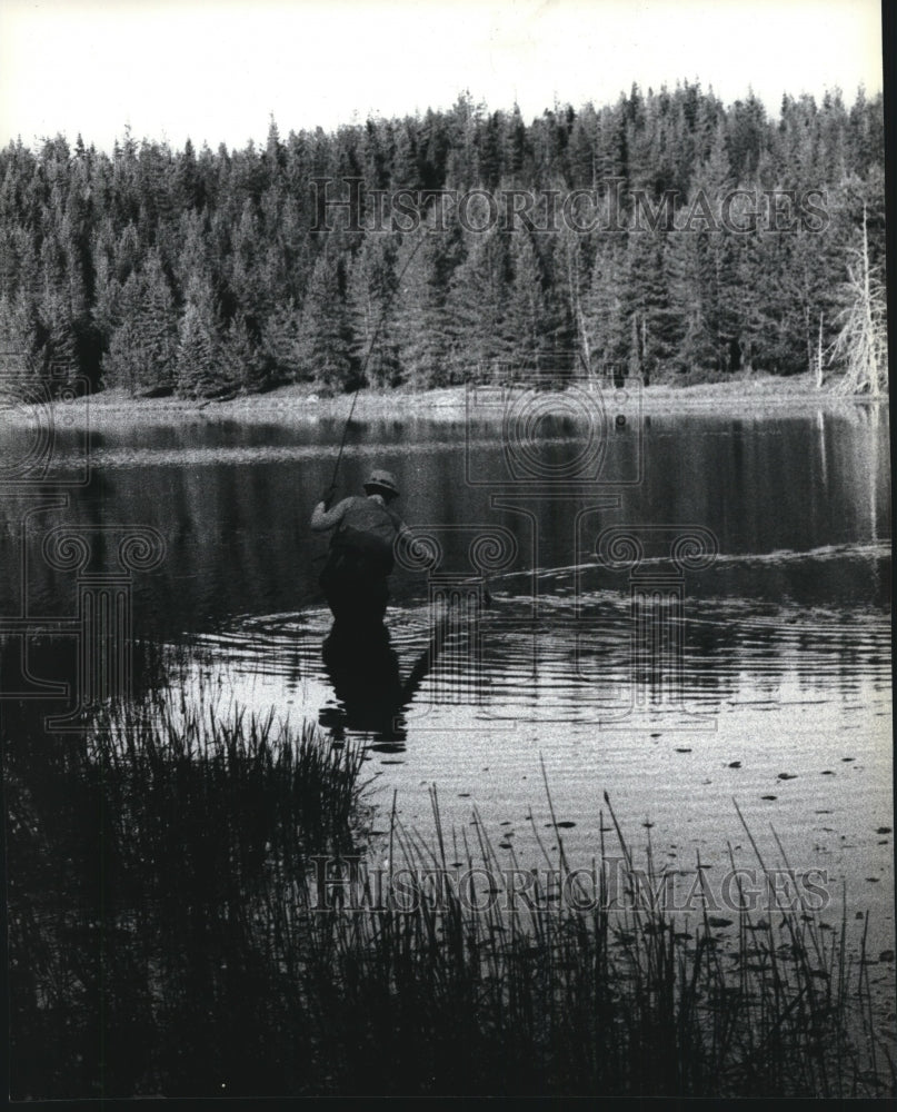1979 A man seen patiently fishing in a lake  - Historic Images