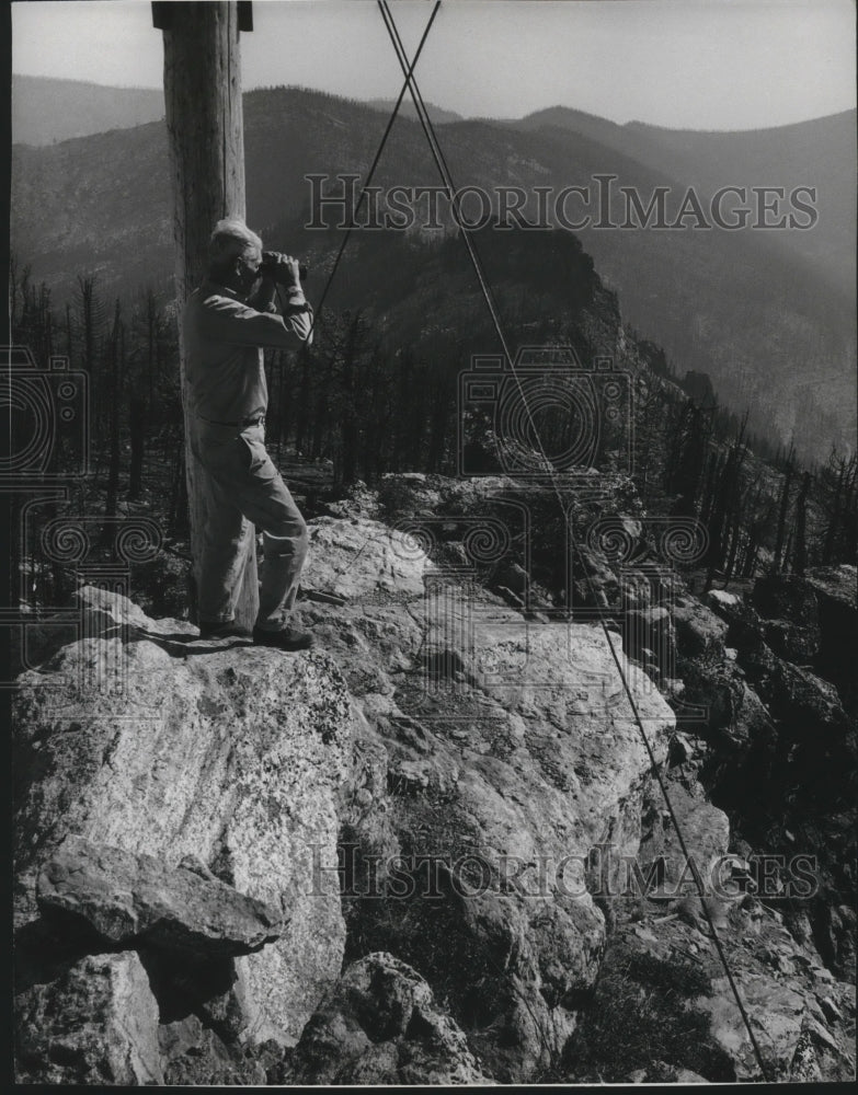1968 Press Photo A man uses his binoculars to observe the forest fire - Historic Images