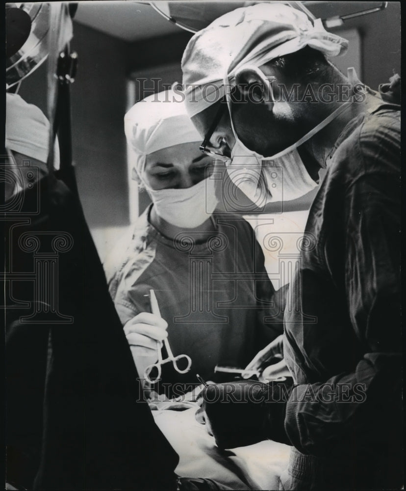 1977 Press Photo Miss Webb & Dr Berg, Operating on patient at Sacred Heart Hosp - Historic Images