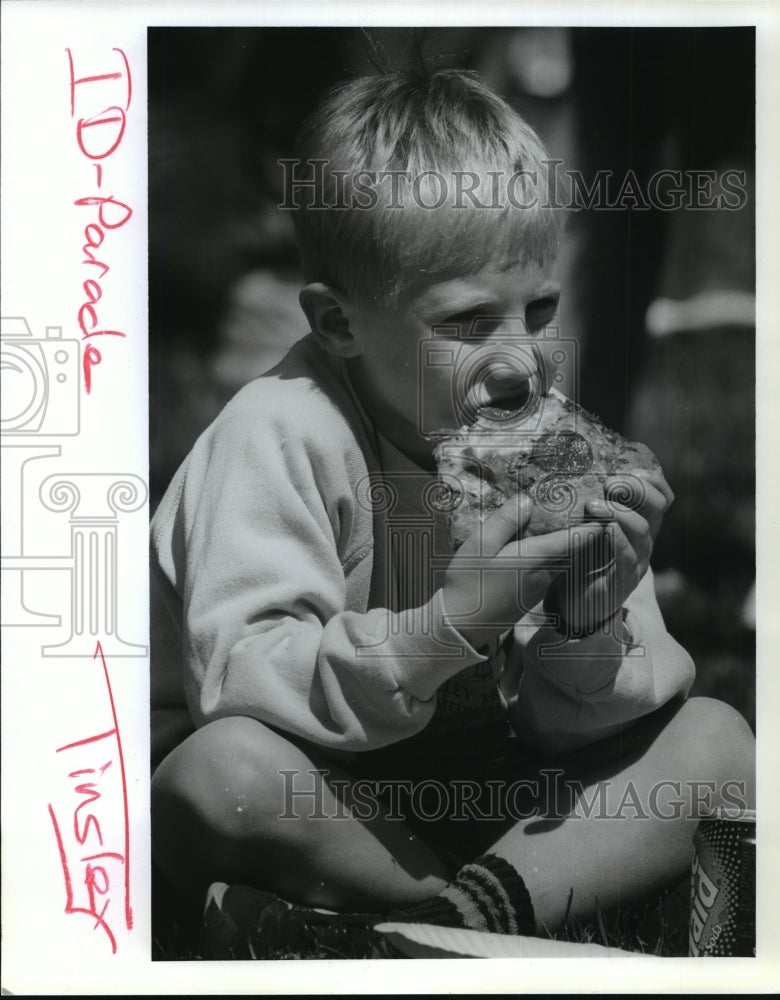 1993 Press Photo A boy eats a pizza while waiting for the parade - spa71790 - Historic Images