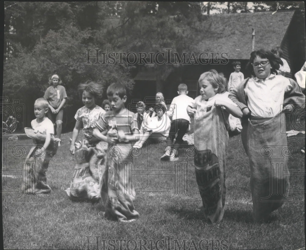 1964 Press Photo Children having fun during sack race game - spa72116 - Historic Images