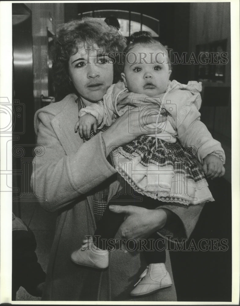 Press Photo Woman carries baby girl which is under her custody - spa73120 - Historic Images