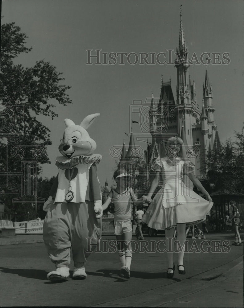 1981 Press Photo Alice and the White Rabbit walk with a kid in Disneyland - Historic Images