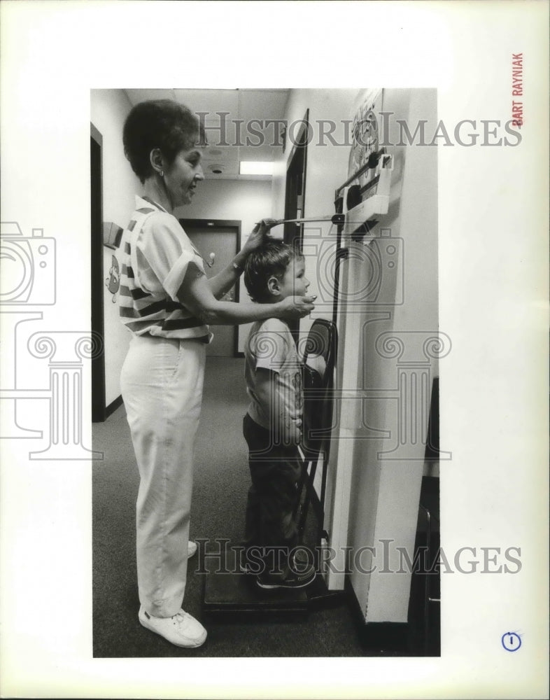 1989 Press Photo Nurse Gini Nibler Checks Johnny Holiday's Height at Clinic - Historic Images