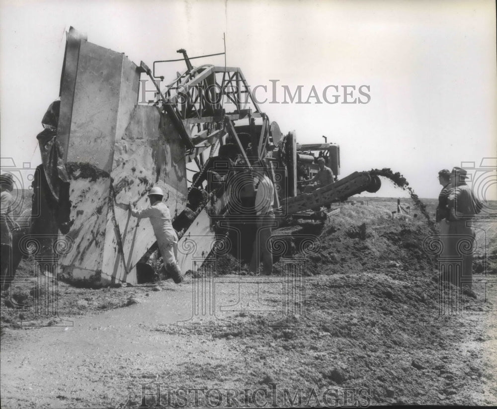 Press Photo Workers making good used of a Construction machinery - spa77422 - Historic Images