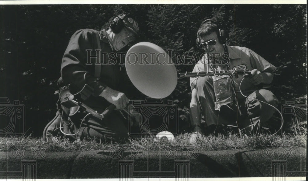 1987 Press Photo Gene Mullen & Dick Schneberger use metal detectors to dig coins - Historic Images