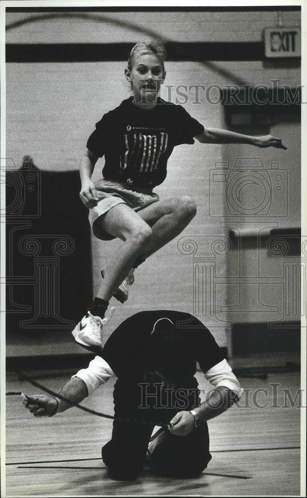 1991 Press Photo Lindsey Heebink leaps on a jumping rope over coach Doug Segur - Historic Images