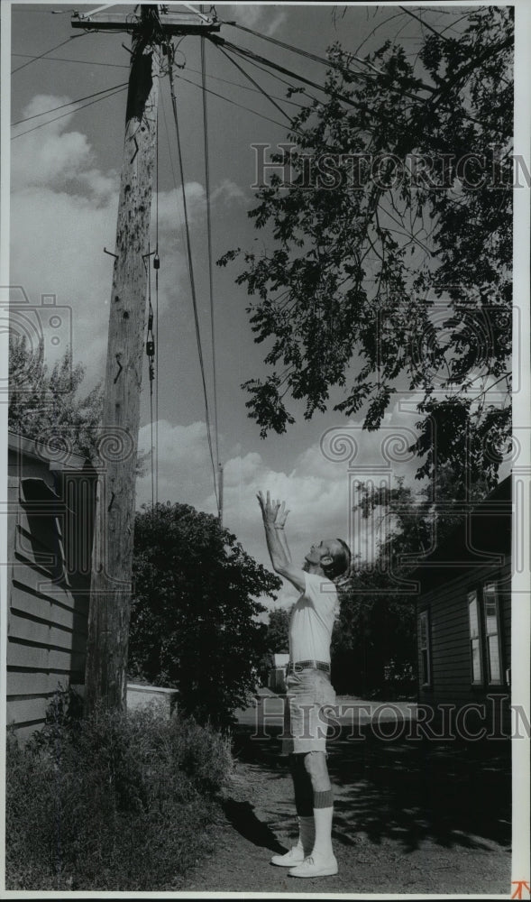 1991 Press Photo Resident Henry Johnson looks up at the telephone pole - Historic Images