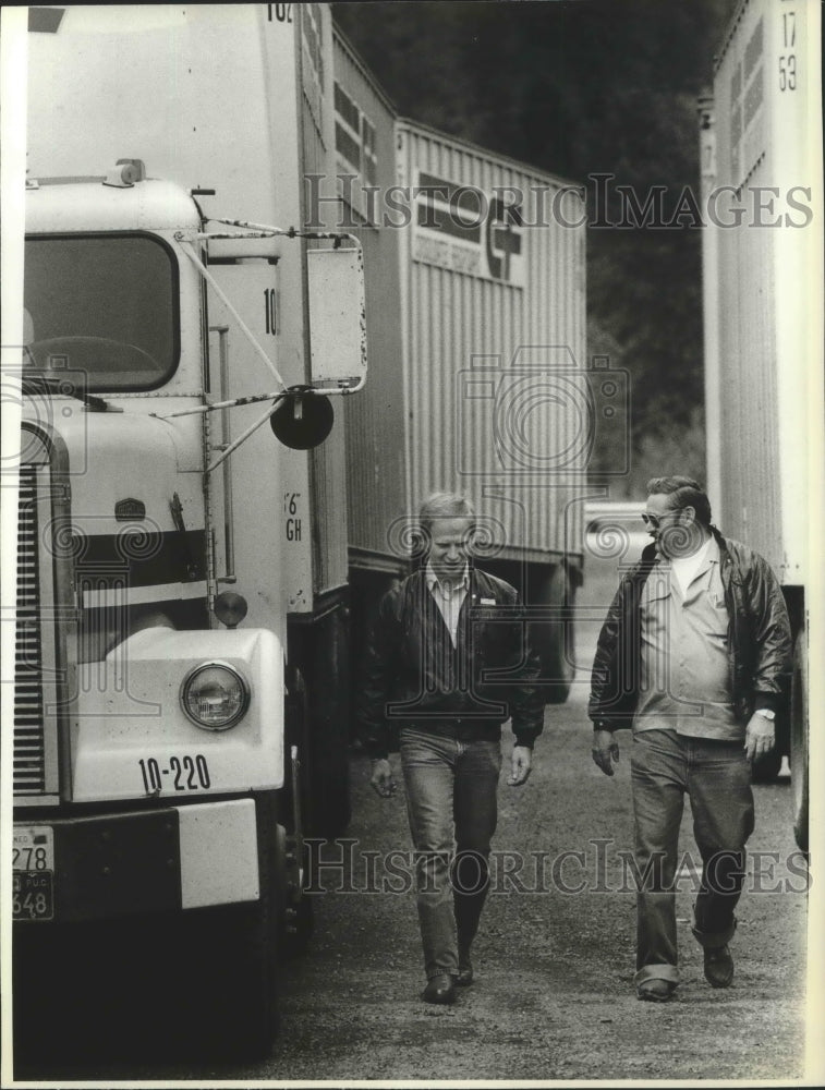1989 Osburn truckers Ron Dubs and Jim Johnson walk alongside trucks-Historic Images