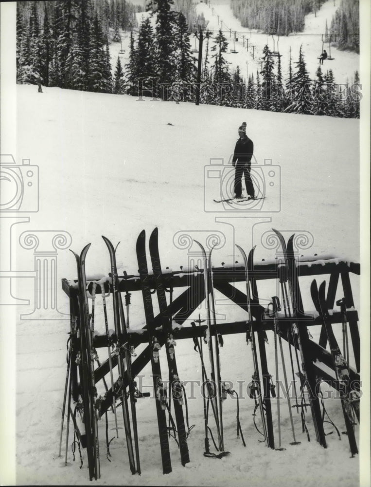 A rack of skis near a lodge at the base of a mountain-Historic Images
