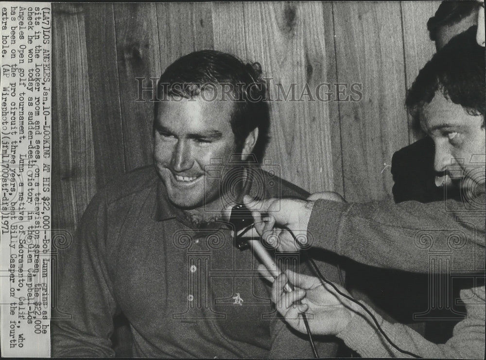 1971 Press Photo Golfer Bob Lunn grins looking at the $22,000 check he won - Historic Images