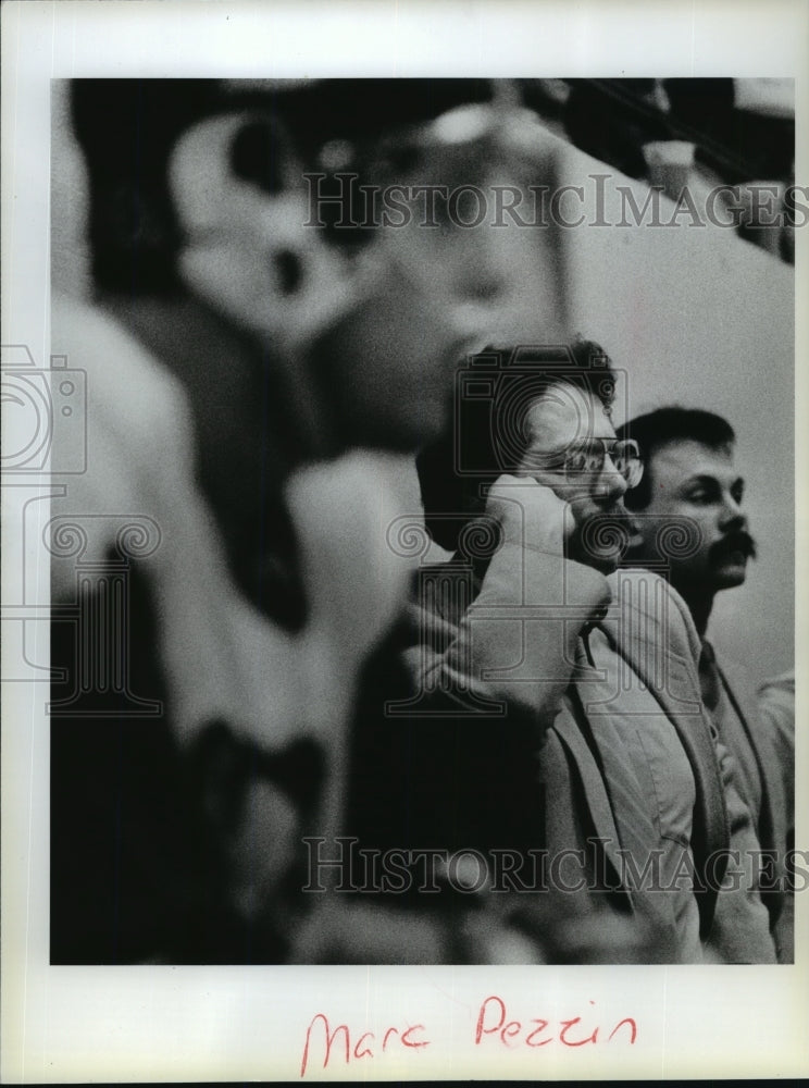 1986 Hockey coach Mark Pezzin watches the game - Historic Images