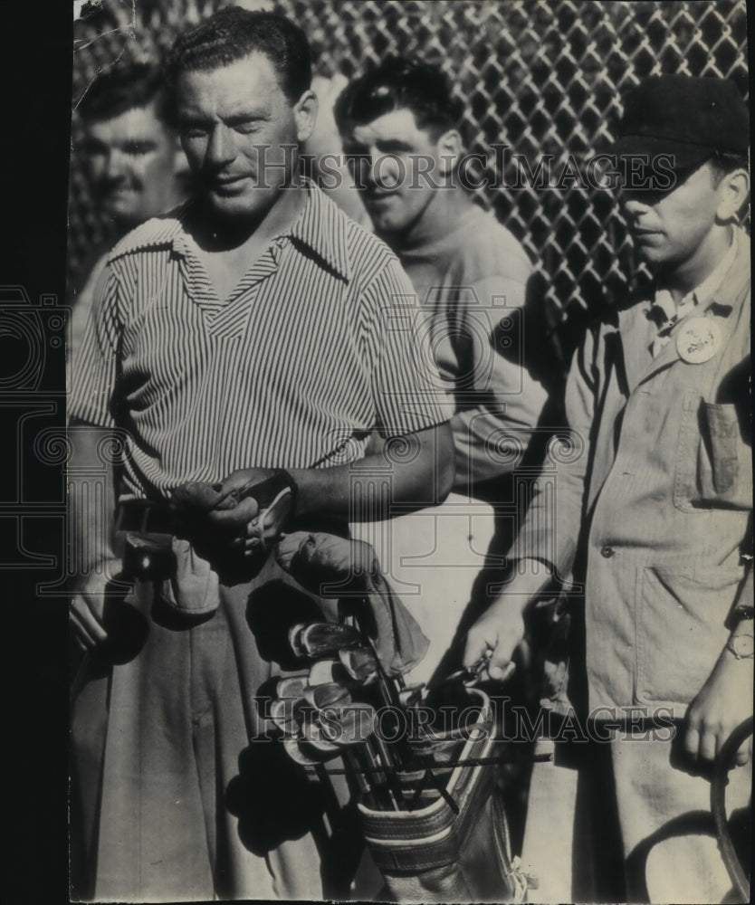 1946 An unidentified golfer and his caddy prepare for a tee shot - Historic Images