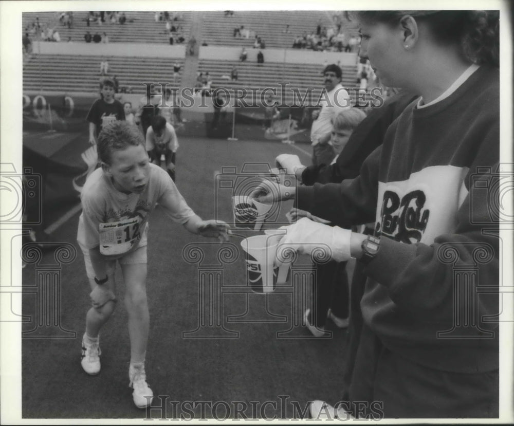 1990 Press Photo 1990 Junior Bloomsday runner gets some water - sps14795- Historic Images