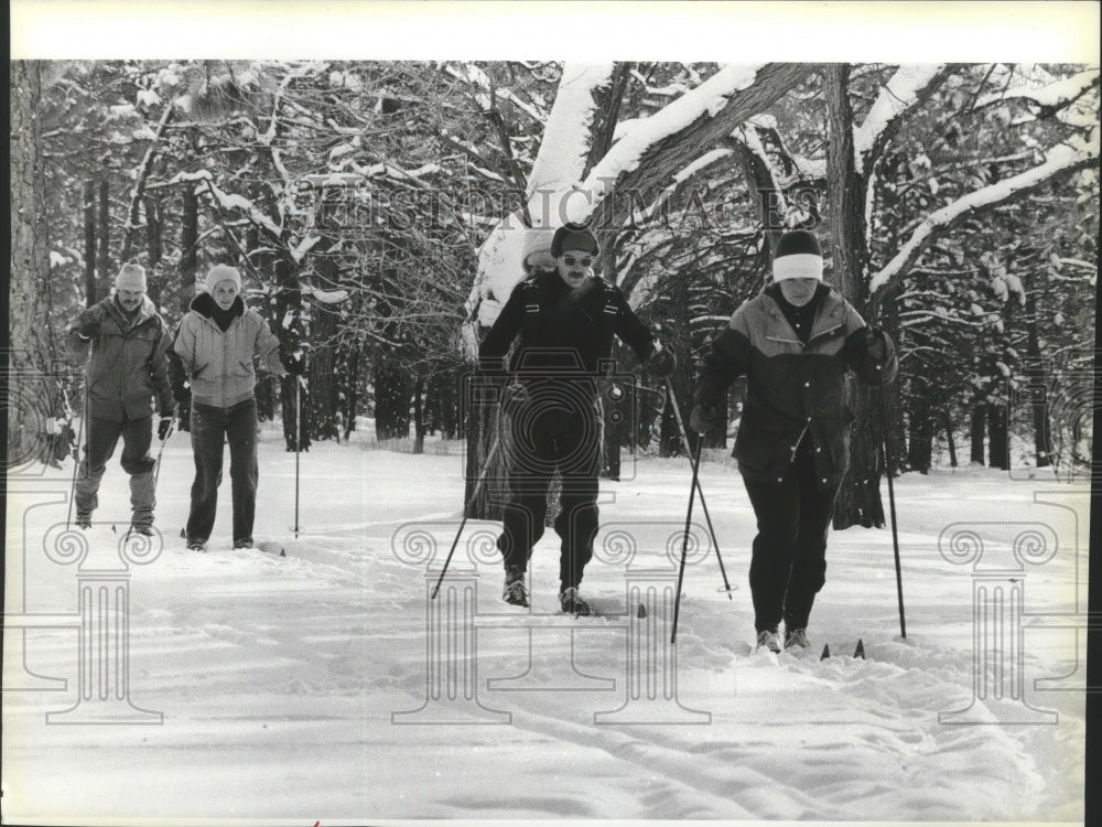 Press Photo A quartet of cross-country skiers make their way down a trail - Historic Images