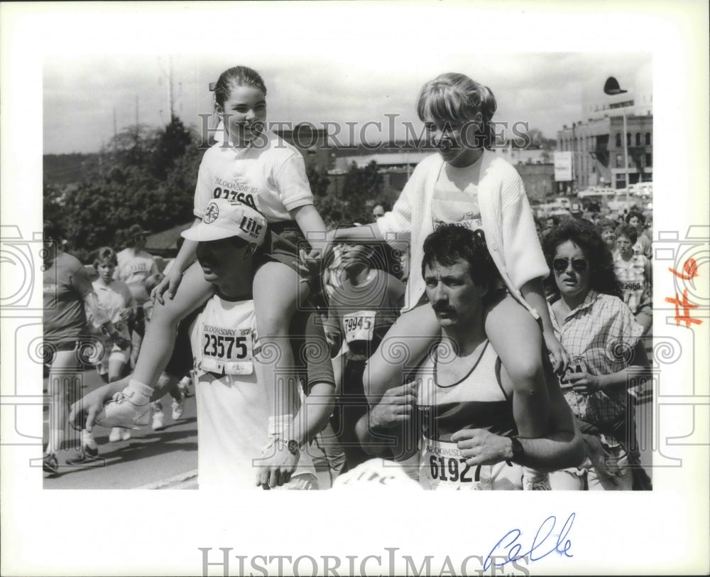 1987 Press Photo Young gals get lift from dads near finish line of Bloomsday run-Historic Images