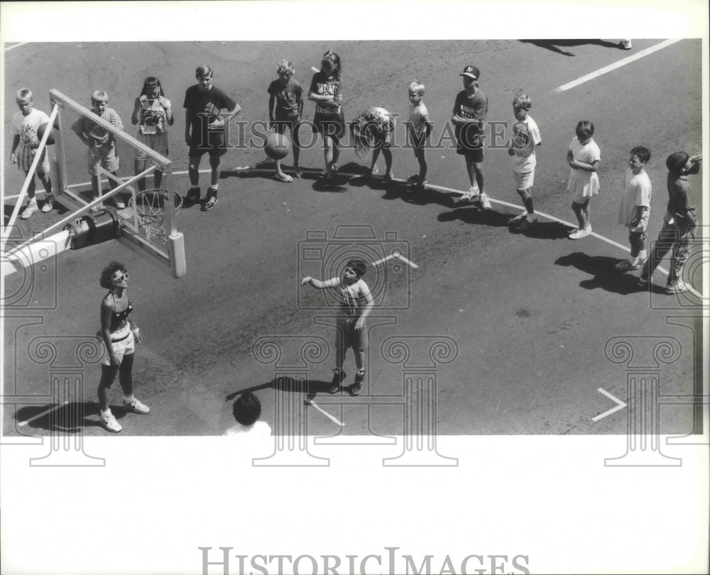 1990 Kids wait around basketball arc for turn at Hoopfest shooting - Historic Images