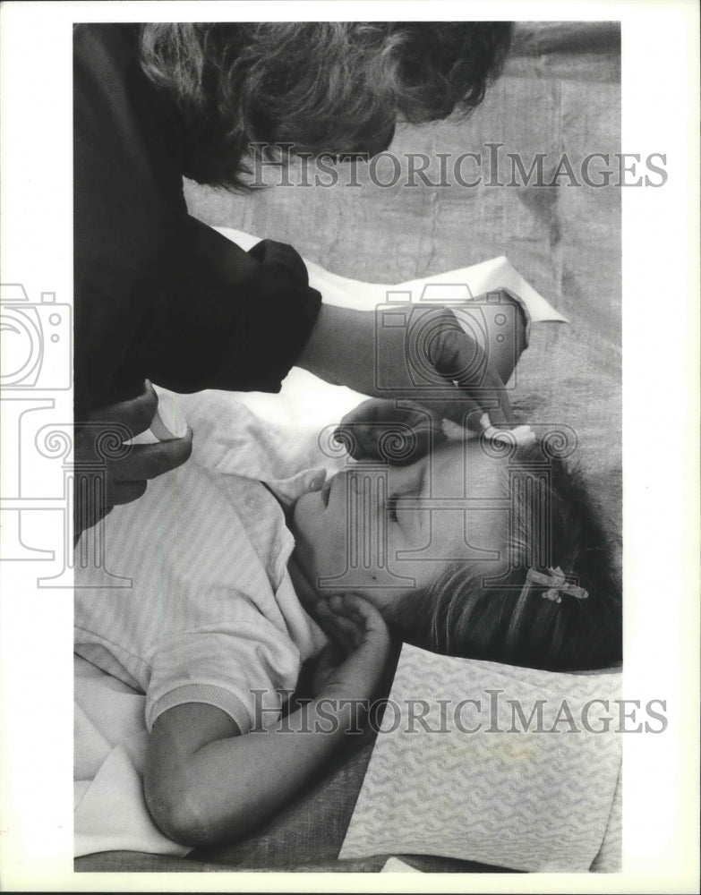 1988 Press Photo Little girl&#39;s abrasions treated by volunteer for Bloomsday race- Historic Images