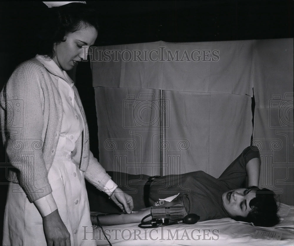 1957 Joann Harvey prepares to give blood with nurse Betty Plante - Historic Images