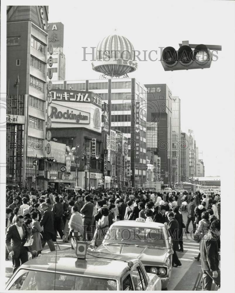 Press Photo A busy street scene with people, cars and buildings in Japan.- Historic Images