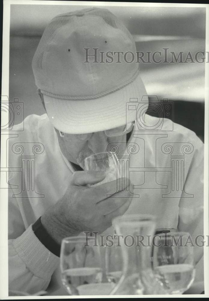 1986 Press Photo Cliff Fulton sniffs the bouquet of wine at NY State Fair- Historic Images