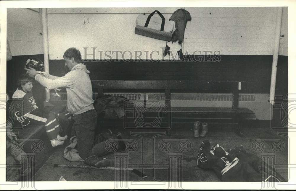 1988 Press Photo Dan Britt Dresses Son Chuckie to Play Hockey - sya51124 - Historic Images