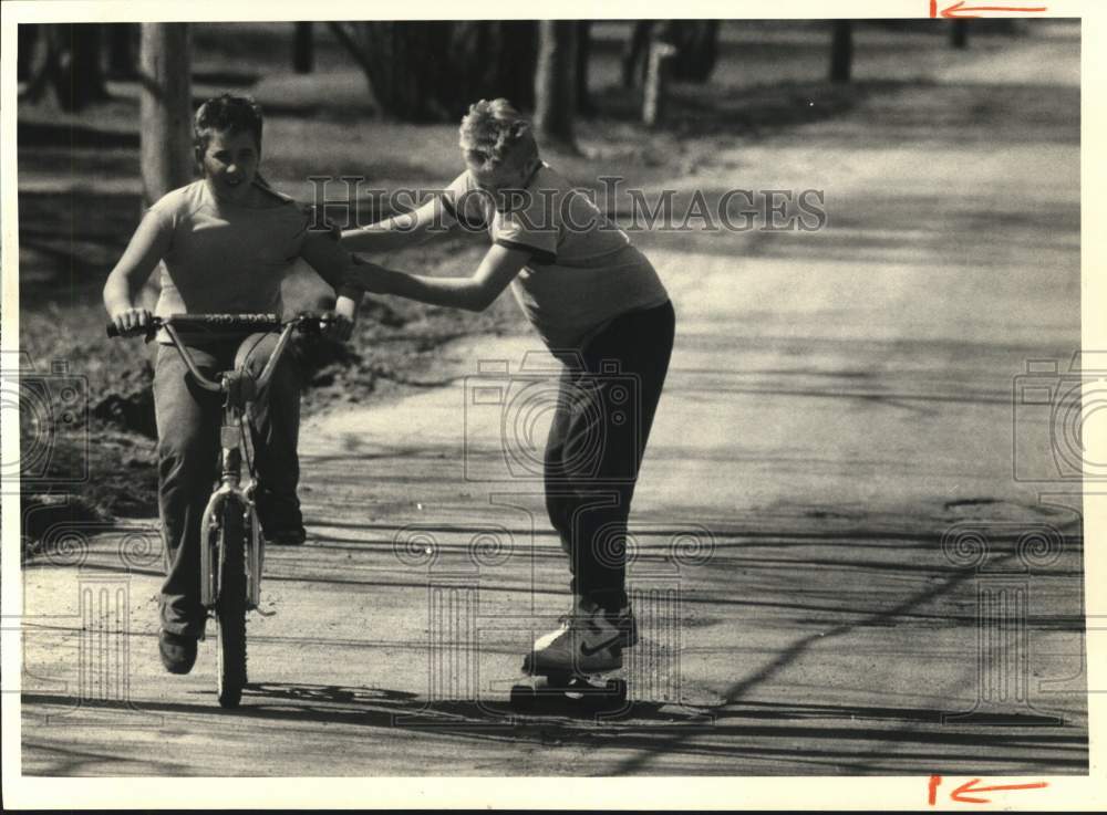 Press Photo Skateboarder Brian Wilbur with Friend Randy Hamlet on Bicycle - Historic Images