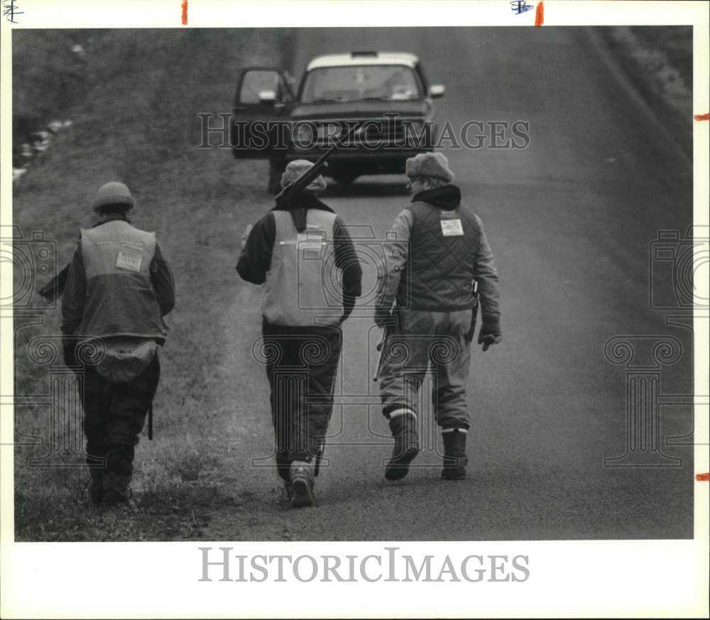 1990 Press Photo Niles, New York-Deer hunters walk down Cayuga County road - Historic Images