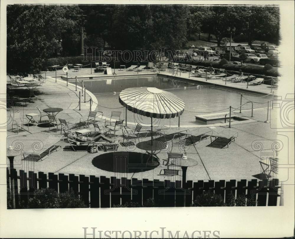 Press Photo Woman sunbathes beside Swimming Pool - sya68435- Historic Images