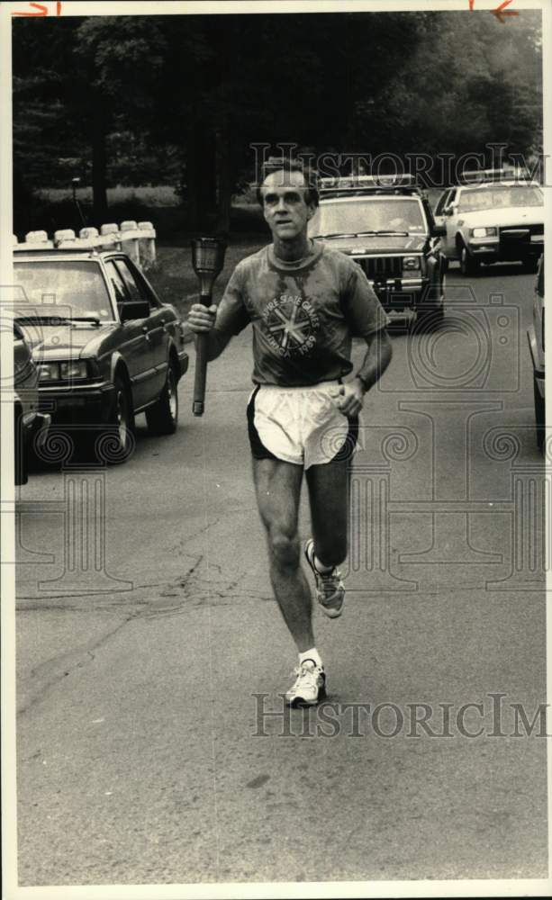 1989 Press Photo Don Farley of Ithaca, runs with Empire State Games Torch - Historic Images