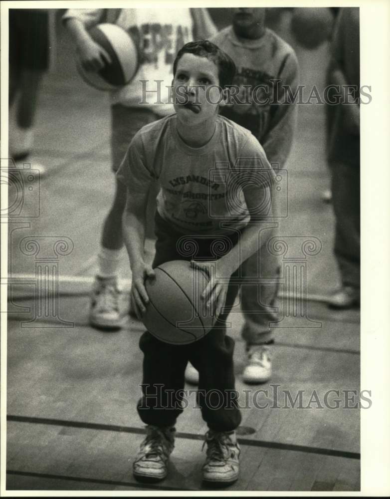 1989 Press Photo Drew Olson sticks tongue out as he shoots basketball at OCC gym - Historic Images