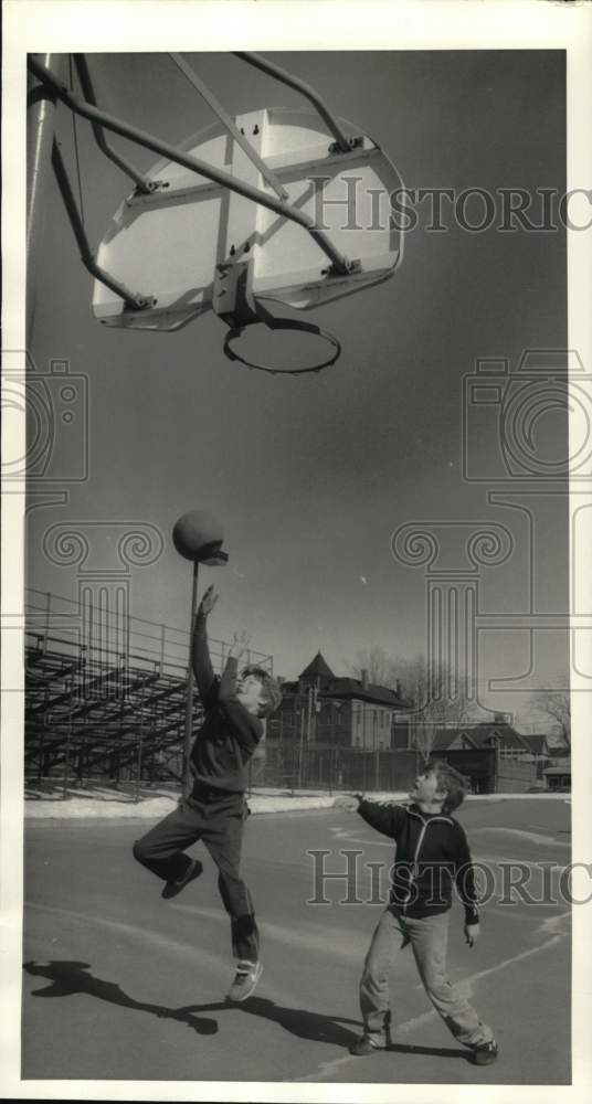 1986 Press Photo Two young boys play basketball on an outdoor court - sys08613 - Historic Images