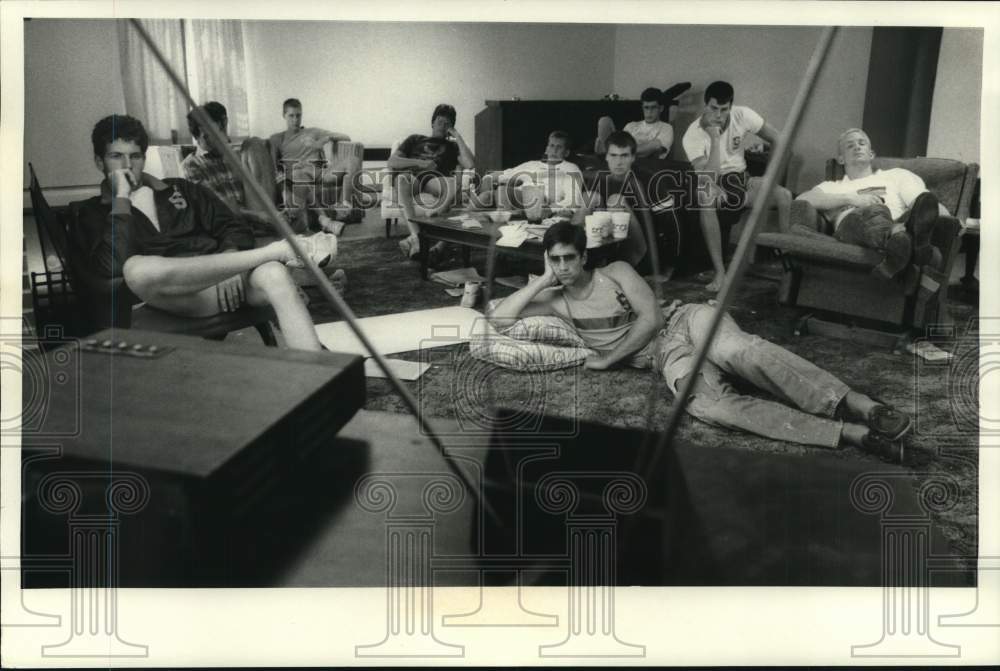 1985 Press Photo Syracuse University Crew members relax and watch television - Historic Images