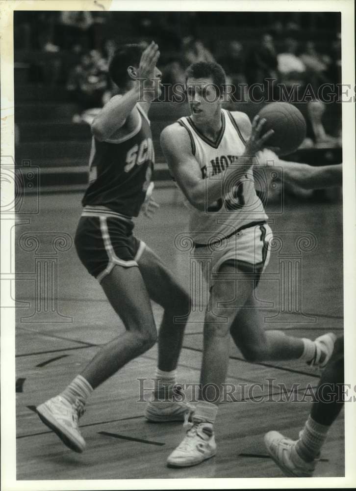 1987 Press Photo LeMoyne College basketball player Len Rauch drives by defender - Historic Images