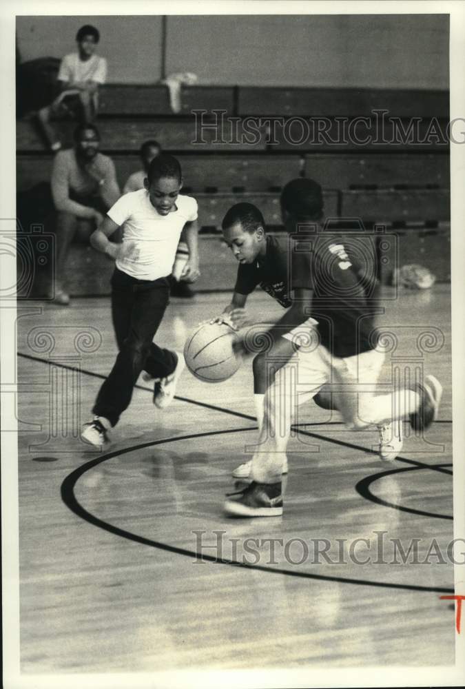 1987 Press Photo Biddie League basketball player L. Williams dribbles by players - Historic Images