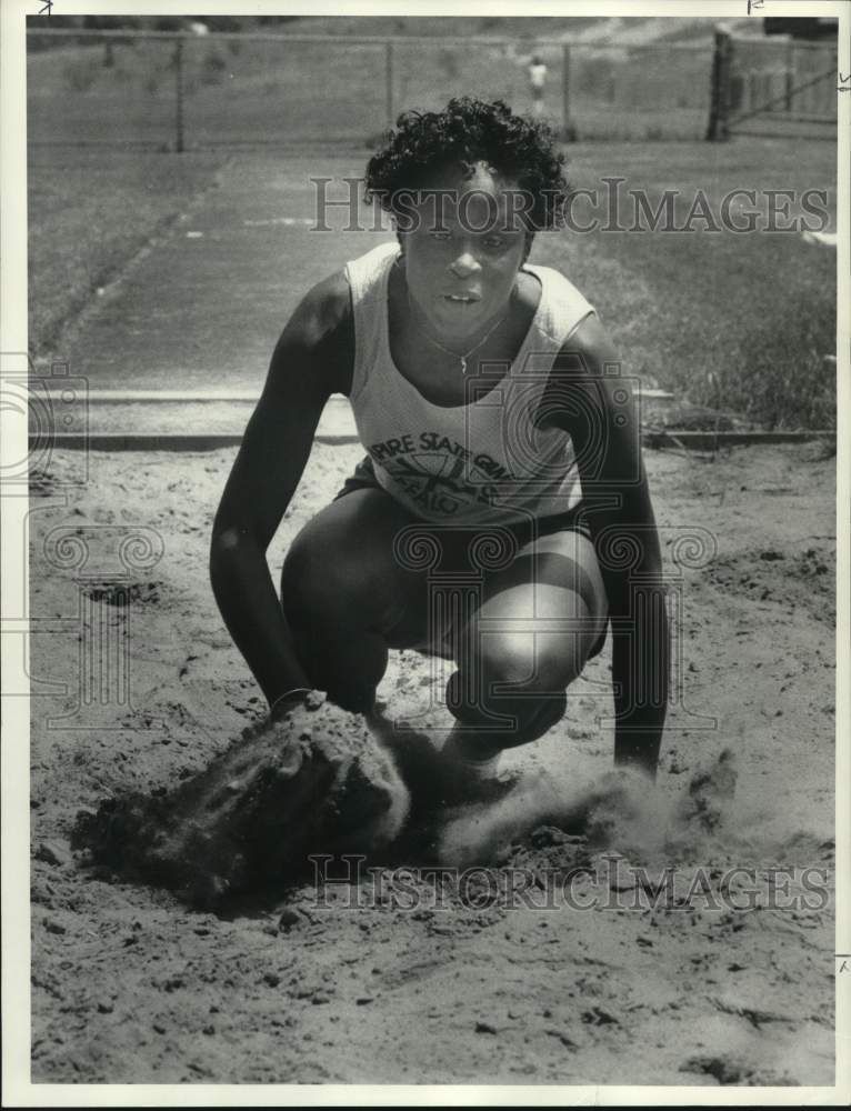 1986 Press Photo Syracuse U track athlete Janeen Bonner lands in sand after jump- Historic Images