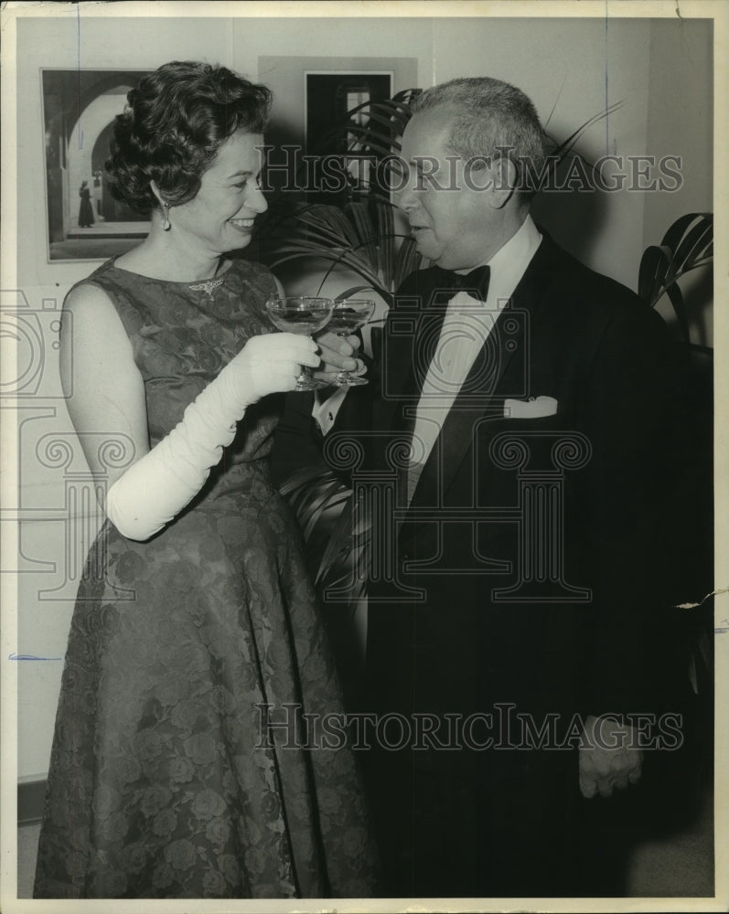 1960 Mrs. David Williamson toasts male companion - Historic Images