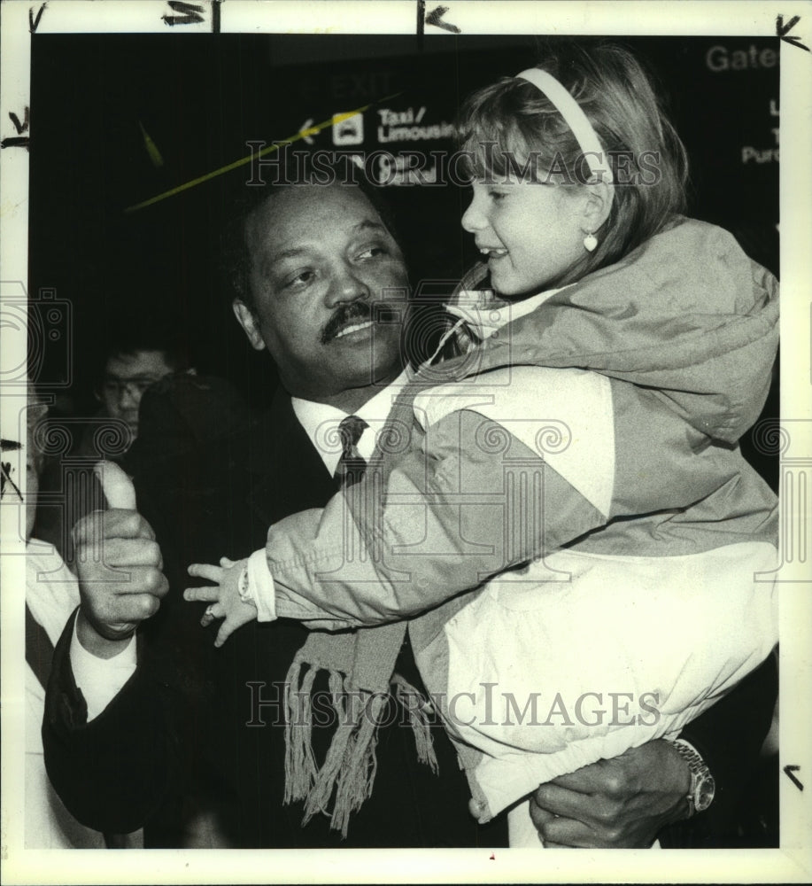 1992 Press Photo Jesse Jackson lifts Lynn Serfilippi, 7, at Albany, NY airport - Historic Images