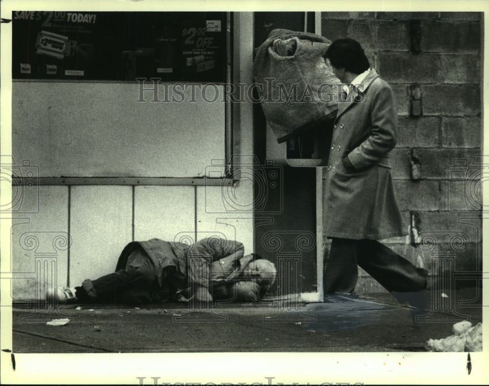 1986 Press Photo Pedestrian passing homeless person on Albany, New York street - Historic Images