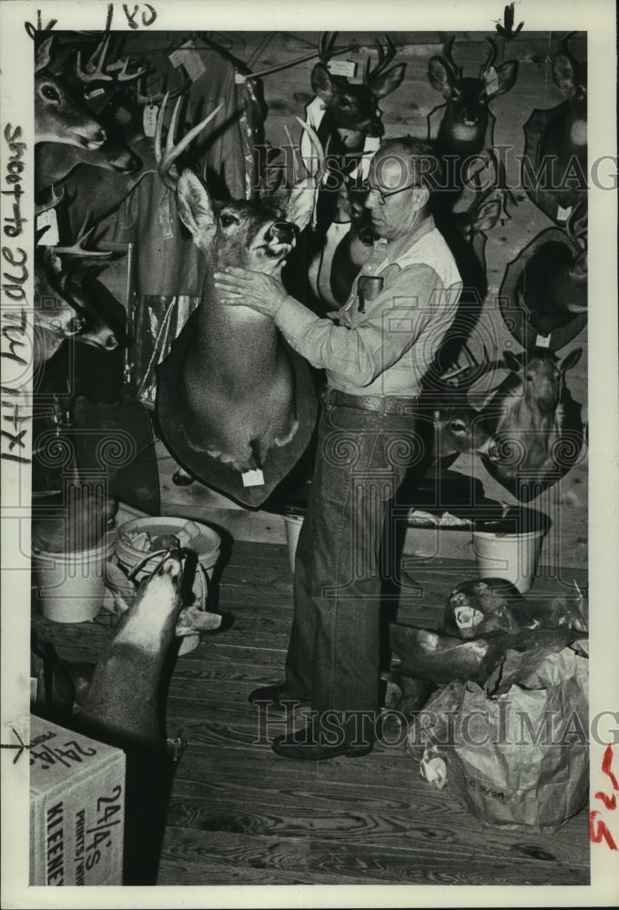 1982 Press Photo Taxidermist George L. Whitman inspects deer head in his shop - Historic Images