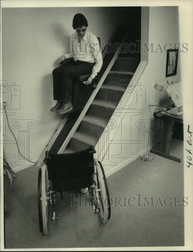 1985 Press Photo Dick Ruszinski of Albany, New York rides lift chair down stairs - Historic Images