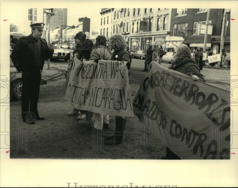 1986 Press Photo Police officer gives warning to protestors on Albany, NY street - Historic Images