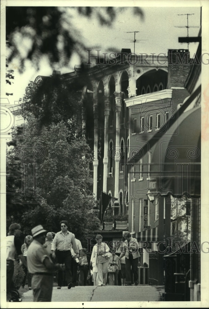 1982 Pedestrians walk along sidewalk in Saratoga Springs, New York - Historic Images