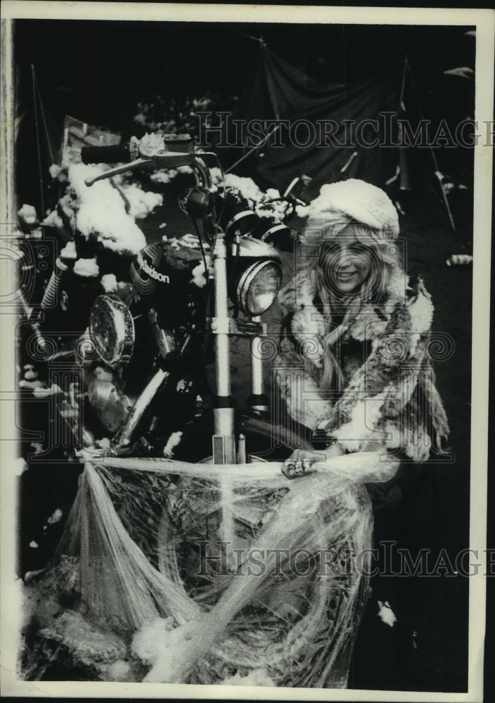 1977 Press Photo Bonnie Hamilton unwraps motorcycle in Syracuse, New York - Historic Images